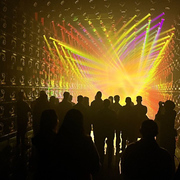 A group of silhouetted visitors stand in front of colourful, geometric projections at teamLab Borderless in Tokyo, Japan
