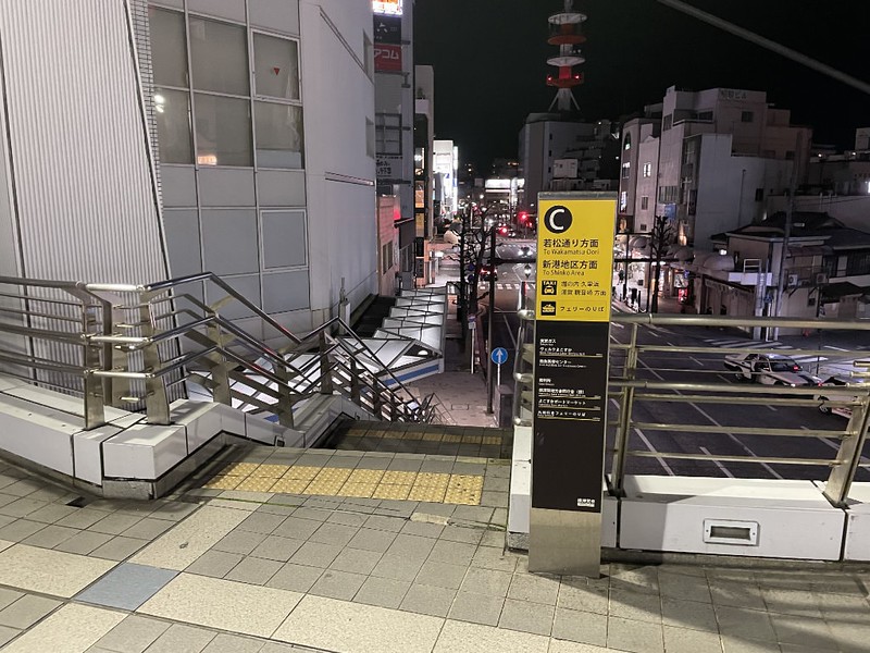 Stairs down to street level with informational signage outside the east exit at Keikyu Yokosuka-chuo Station