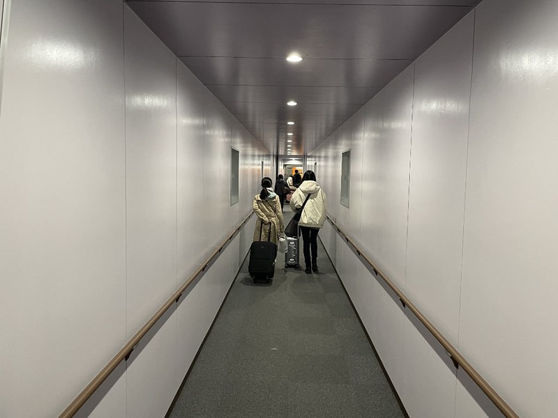 A view from behind of the narrow corridor in the boarding bridge leading from the Tokyo Kyushu ferry terminal to the ship