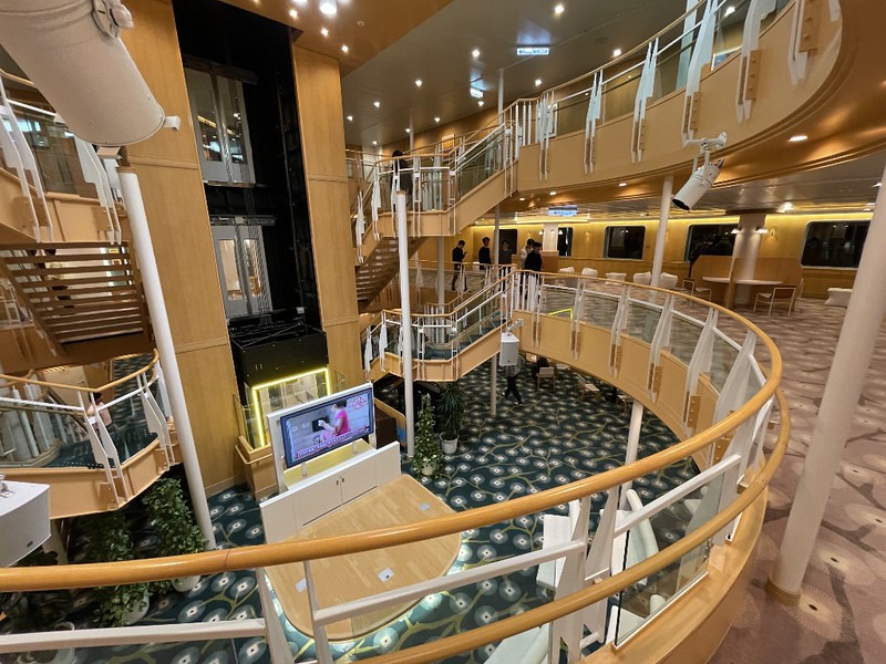 A view from above of the lobby area, main atrium, and upper floors of the Ferry Soleil, connected by stairs and an elevator
