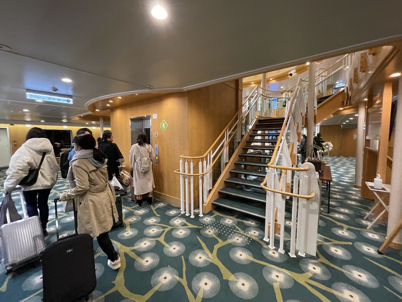 Passengers with wheeled cases board the elevator to get to their cabins on the Ferry Soleil