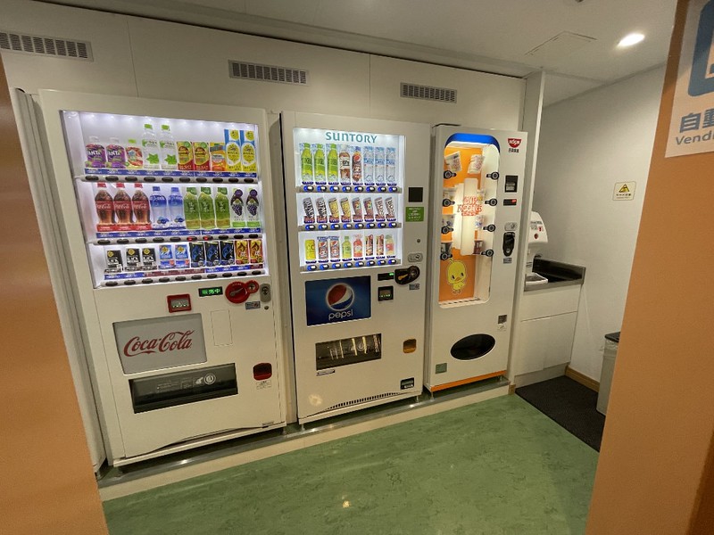 A small hallway on the Ferry Soleil with a row of vending machines selling drinks and noodles