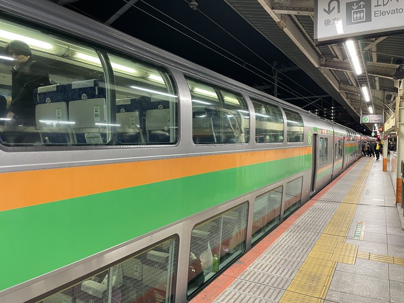 View along the platform of the double decker orange and green Tokaido Line train to Yokohama on the platform at Tokyo Station