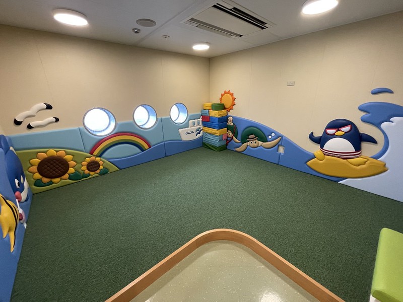 Children’s play area on the Ferry Soleil with colourful images on the wall, soft bricks, and portholes looking out at the sea