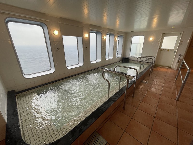 Interior of the men’s baths with window views of the ocean on the Ferry Soleil, Japan
