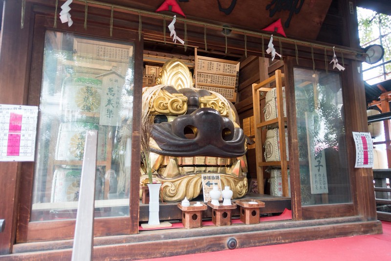 Monumental lion head statue and other religious artefacts at the Namiyoke Inari-jinja Shrine in the Tsukiji district of Tokyo, Japan