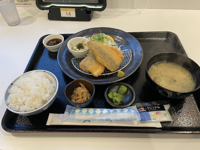A tray with aji furai teishoku (horse mackerel set meal) with bowls of rice, broth, pickles, and sauce in the restaurant on board the Ferry Soleil, Japan