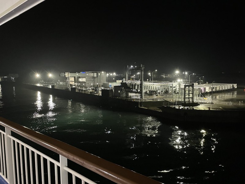 A view from one of the decks of the Ferry Soleil pulls up at the dock in brightly lit Shinmoji at night