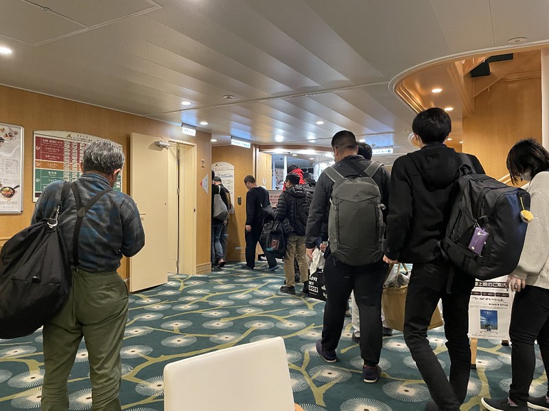 Passengers gather in the lobby of the Ferry Soleil, ready to disembark the ship