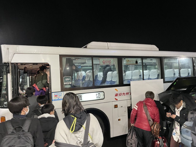 Passengers board a transit bus to Kokura outside the Shinmoji ferry terminal