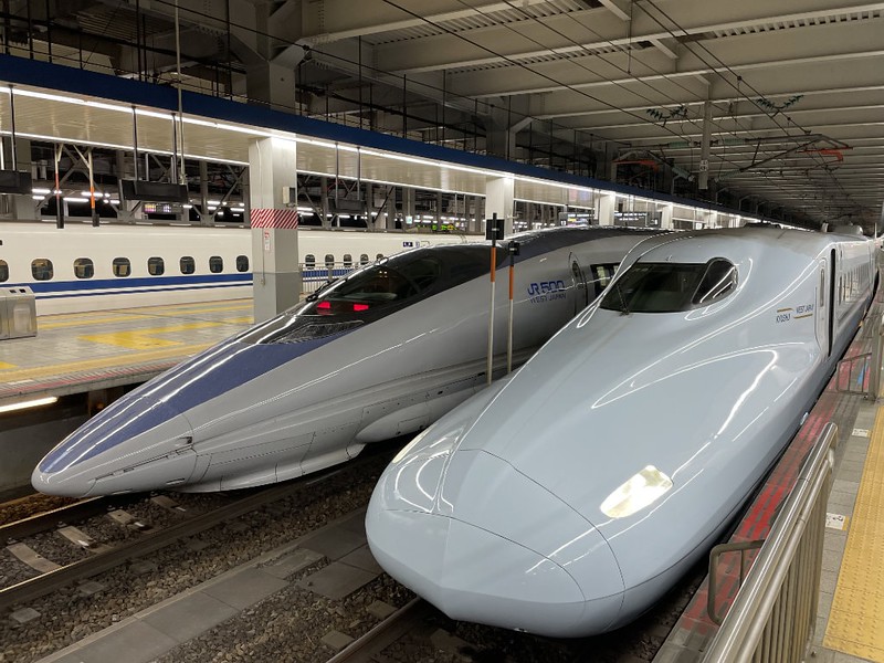 Two shinkansen trains sit side-by-side on the platforms at Hakata (Fukuoka) station in Japan