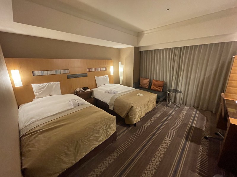 Large twin beds with gold bedspread and wool carpet in the Hotel Okura Fukuoka