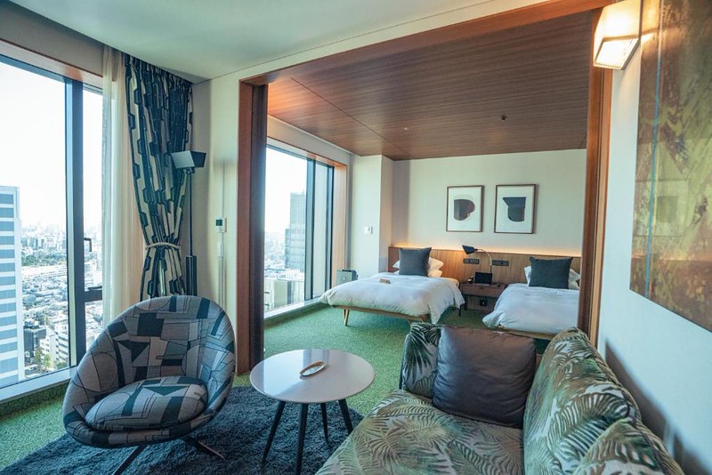 Twin beds and heavily decorated furniture in the living area of a deluxe twin room in The Aoyama Grand Hotel, Tokyo