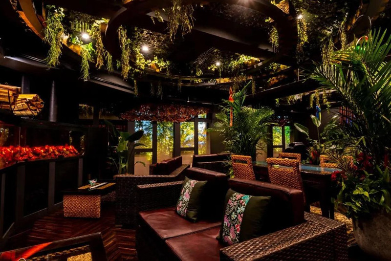 Tropical-style lounge in the BaliAn Resort Forest Ikebukuro, Tokyo, Japan, with indoor palms and leather sofas
