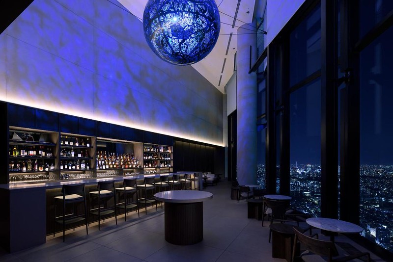 The high ceiling, large lampshade, and commanding city views in the Bellustar Tokyo hotel bar