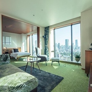 Green and wooden interior of a corner twin suite in the Aoyama Grand hotel, Tokyo, Japan, with city views outside
