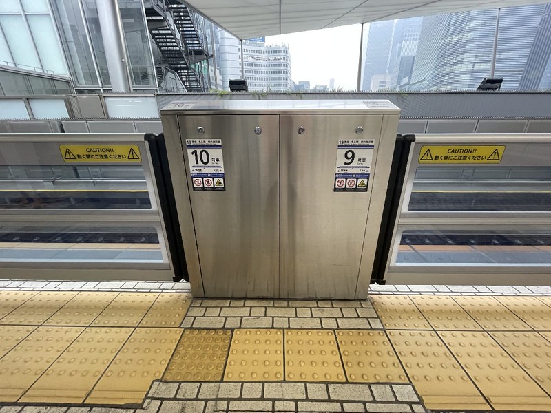 Stickers on the boarding gates for the trains at a Tokyo Shinkansen Line platform showing which number car stops at that point, so passengers know exactly where to board