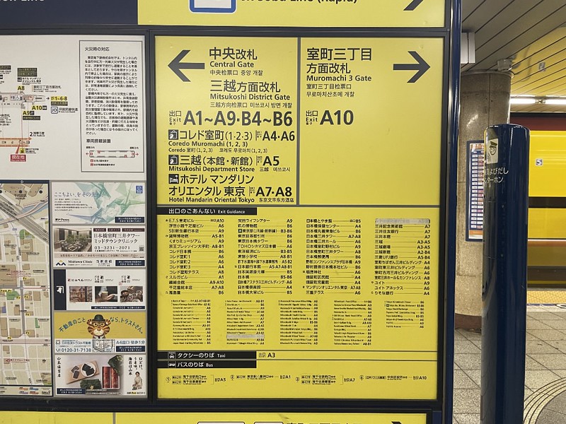 Close up of a Tokyo train station exit info board with directions to exits and other key locations and a map key of other landmarks
