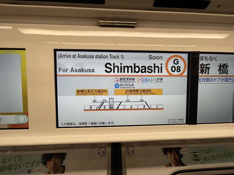Sign on a Tokyo metro train showing how each train car matches with exits, escalators, stairs, and elevators in the next station, with other pieces of useful information for English-speaking passengers