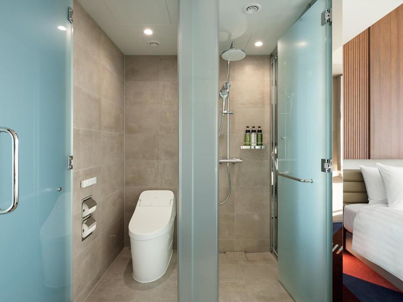 View of the toilet and shower cubicles with blue frosted glass in the Hotel Groove Shinjuku, Tokyo