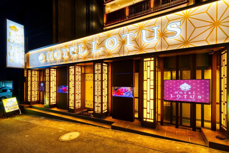 The brightly-coloured exterior of the Hotel Lotus in Tokyo, Japan, with signs in bright lights and video screens