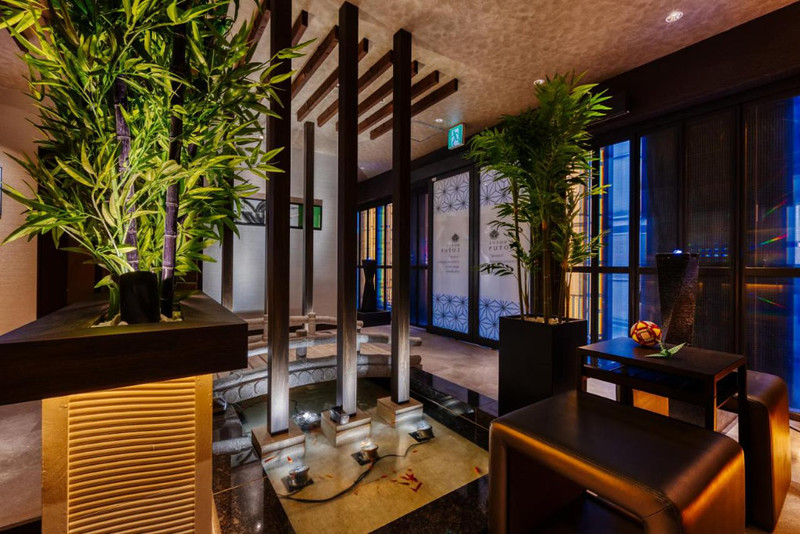 The lobby of the Hotel Lotus in Tokyo, Japan, with wooden pillars and struts, and bamboo plants