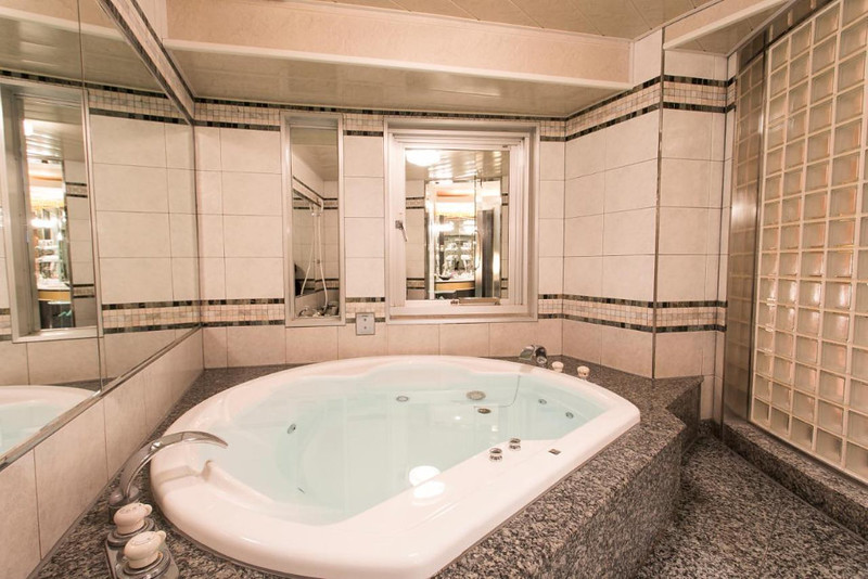 Bathroom in the love hotel PAL Otsuka, Tokyo, Japan, with large, semi-circular bathtub and tiled, mirrored walls