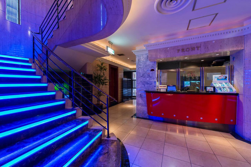 Lobby area in the love hotel PAL Otsuka, Tokyo, Japan, with blue illuminated staircase and red welcome counter