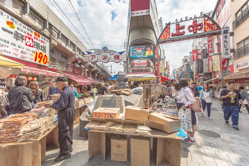 People browsing the fresh food, fish, clothing and watches at Ameya-Yokochō (アメヤ横丁) open-air market in the Taito Ward of Tokyo, Japan, located next to Ueno Station