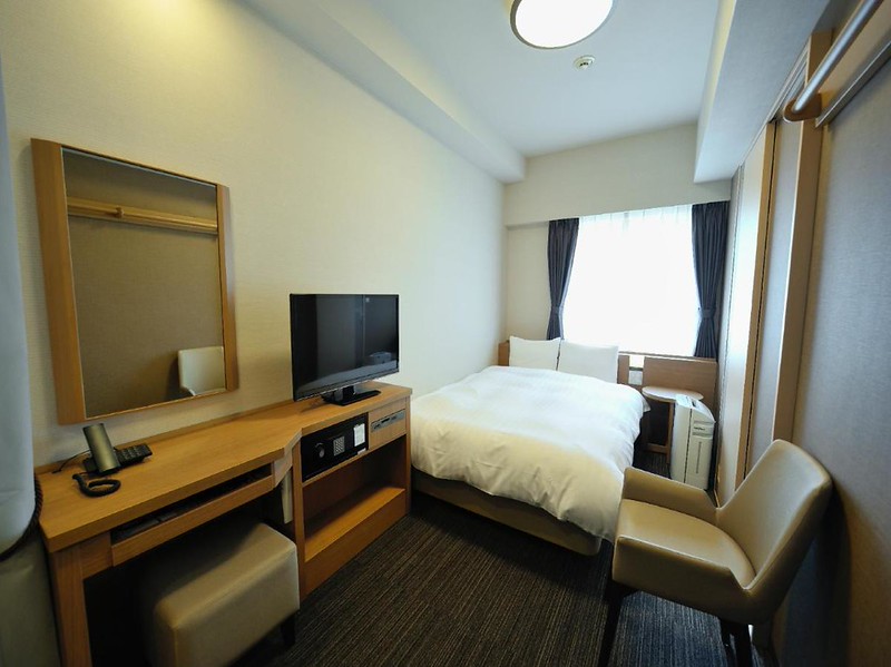 Compact double room with desk and television in the Dormy Inn Akihabara hotel, Tokyo, Japan