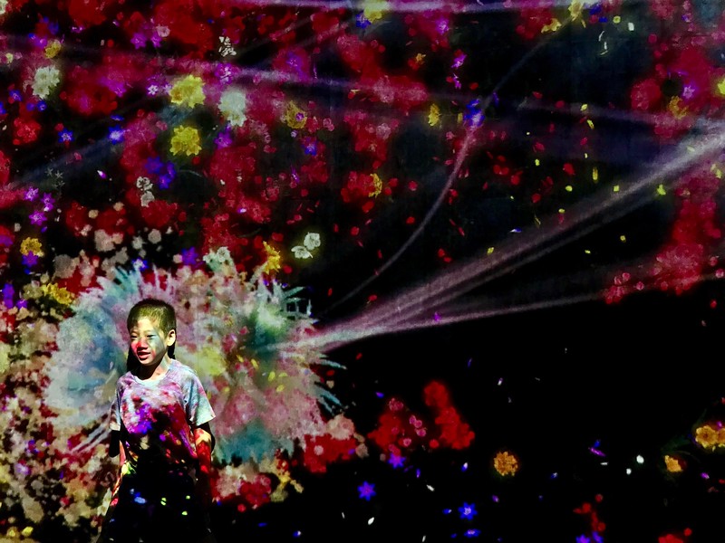 Standing in front of a wall of digital flowers.