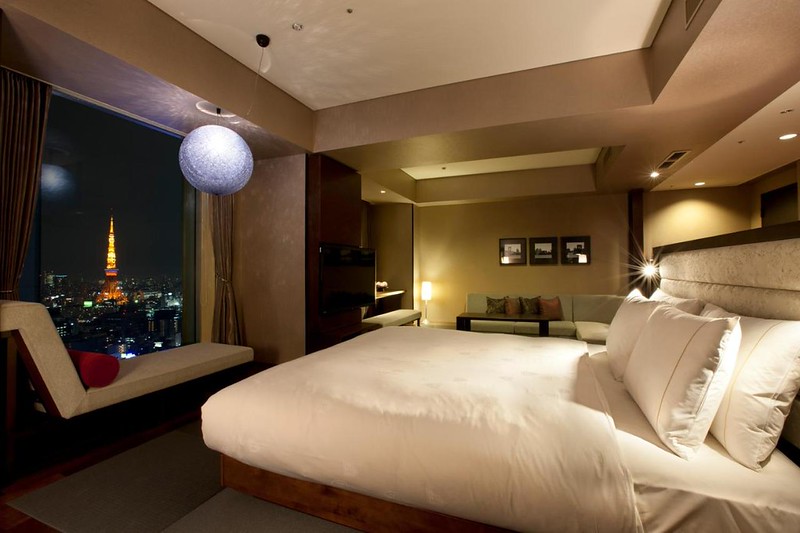 Double bed guest room in Royal Park Hotel the Shiodome, Tokyo, Japan, with window sofa and night views of the city