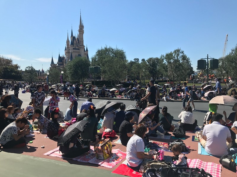 Park goers sitting by the side of the road.