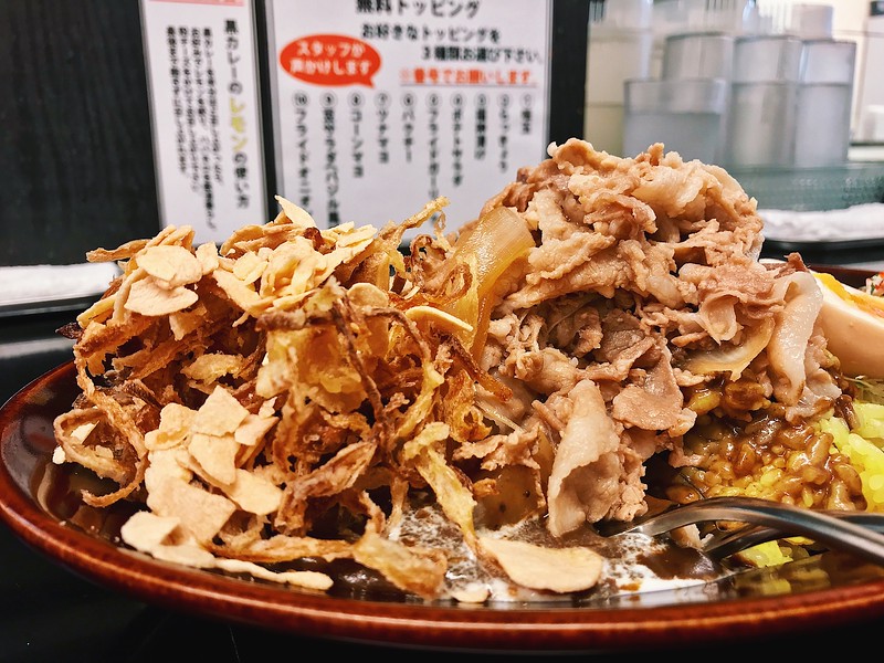 A shower of fried garlic and onions goes onto of the pork.