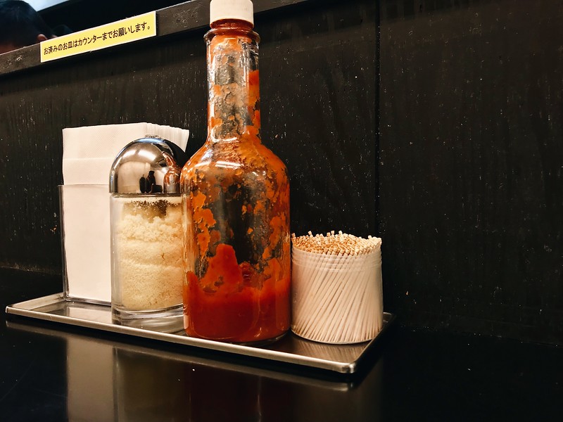 Condiments at the counter include habanero sauce and powdered cheese.