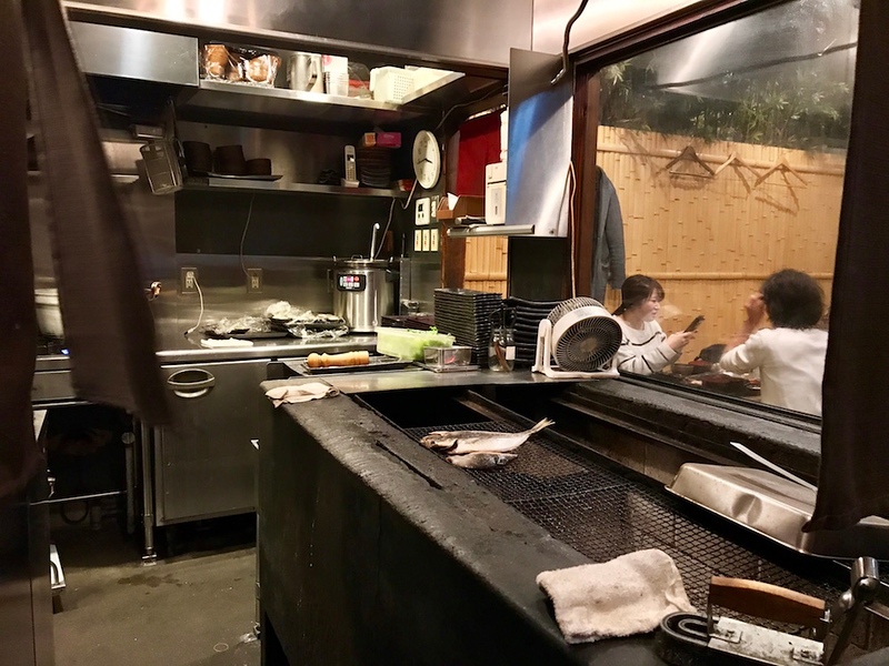 Fish grilling over charcoal.
