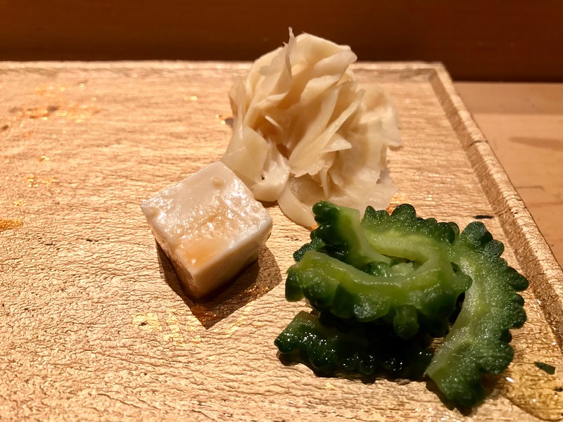 Palate cleansers - an eye-opening salted bitter gourd pickle, a creamy cube of tofu, pickled ginger. Palate cleansers - an eye-opening salted bitter gourd pickle, a creamy cube of tofu, pickled ginger.