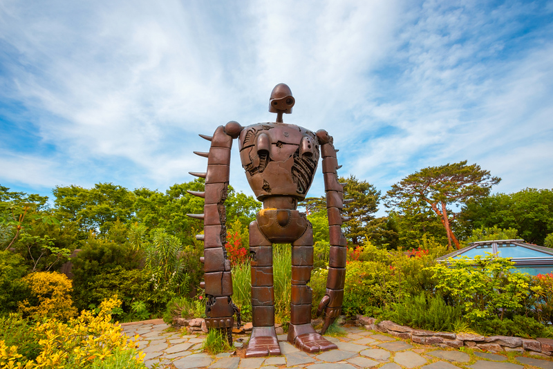 The brown robot sculpture with long arms in the grounds at Tokyo’s Ghibli Museum stands amongst the plants