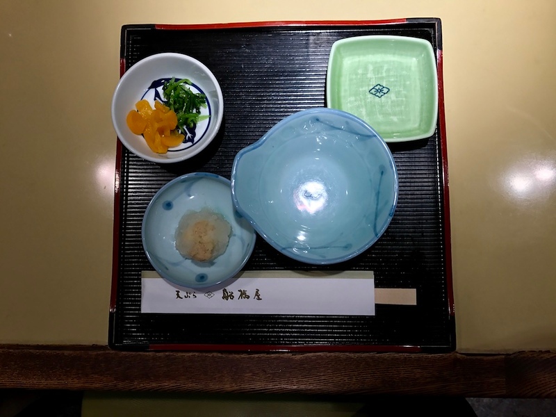 Every diner gets a lacquer tray with empty plates on it.