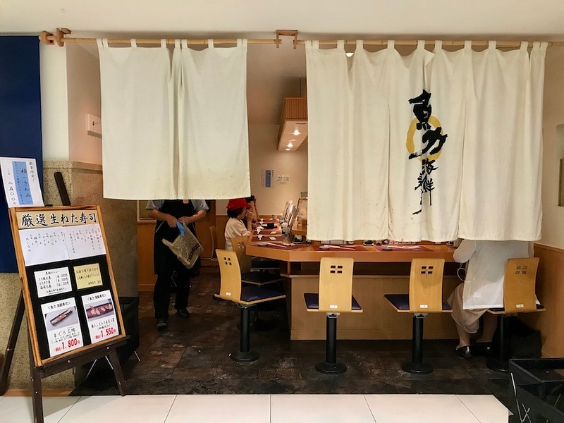 The entrance to Uoriki restaurant is marked by white noren curtains. The entrance to Uoriki restaurant is marked by white noren curtains.