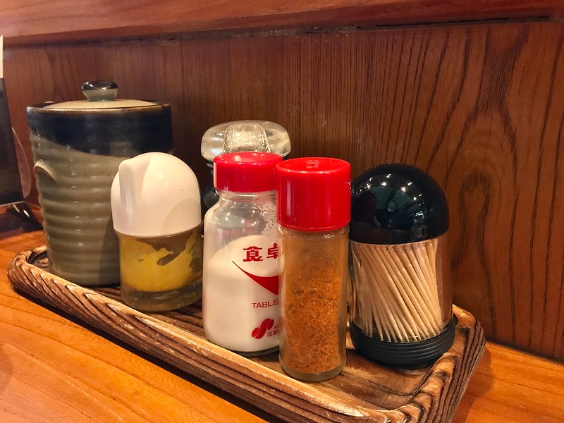 From left to right: tonkatsu sauce, horseradish/yellow mustard, soy sauce, table salt, shichimi seven spice pepper, toothpicks.