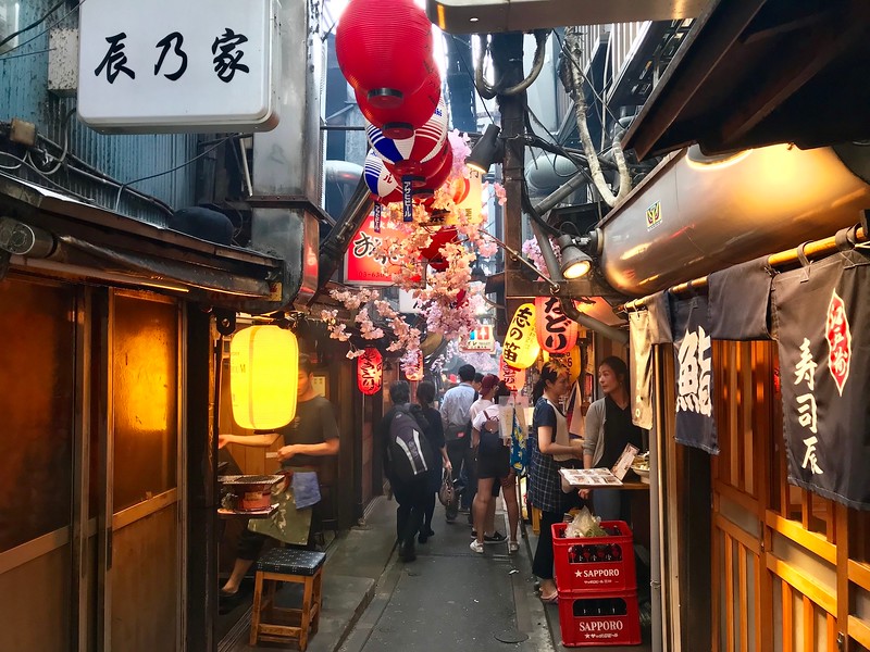 A crush of people amongst the lanterns and restaurant signage in the Omoide Yokocho alleyway