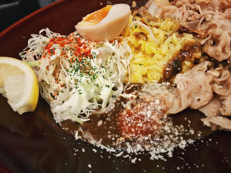 The black curry comes with a slice of lemon. They recommend squeezing it over the sauce and following that with habanero sauce and powdered cheese for different dimension to your curry.