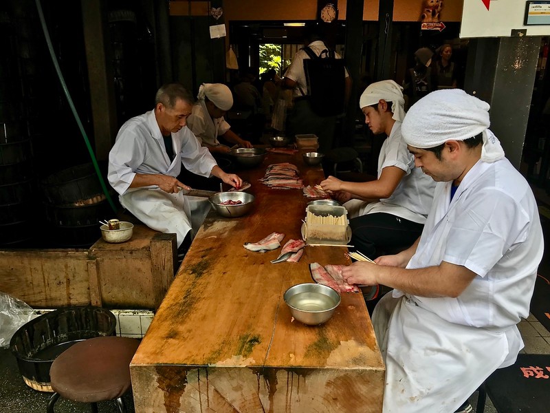 Chefs preparing eel for rice bowls.