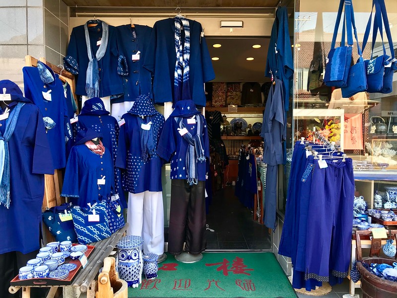 Indigo-dyed clothes shop, with more antiques displayed inside.