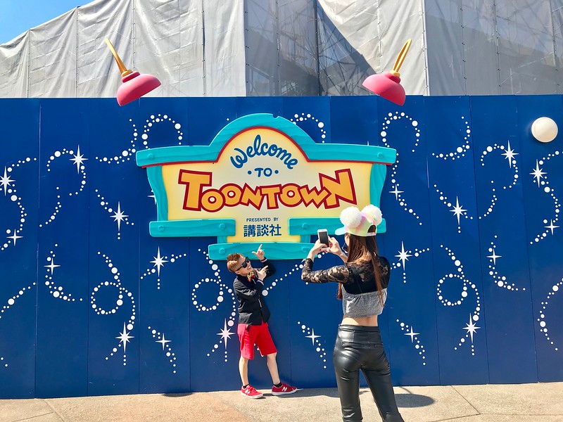 Taking photos in front of a sign for Toontown.