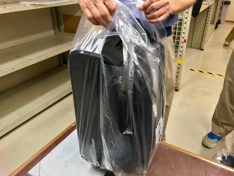 Wrapping a suitcase.