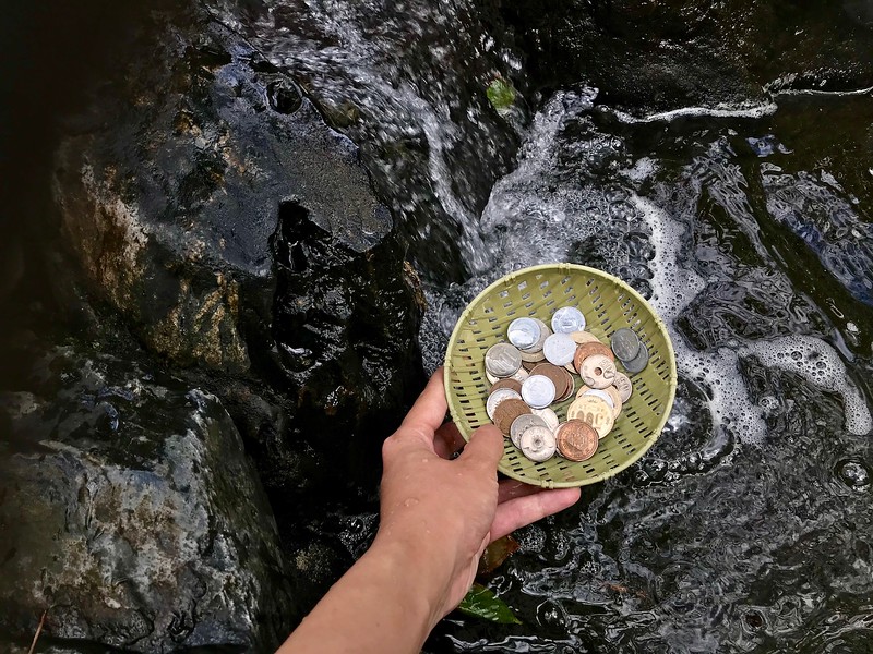 Washing coins in the water.