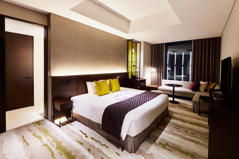 Double bed, living area, and small hallway to the bathroom in the Gate Hotel Tokyo, Japan