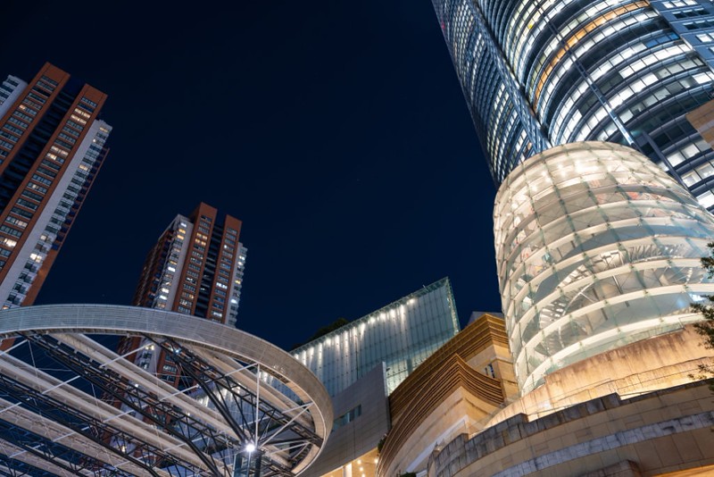Night view from the ground, looking up at the illuminated Roppongi Hills Arena, Tokyo, against the dark sky